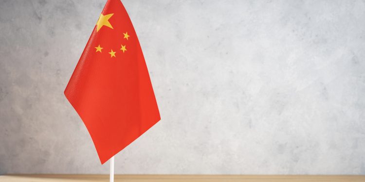 China table flag on white textured wall. Copy space for text, designs or drawings